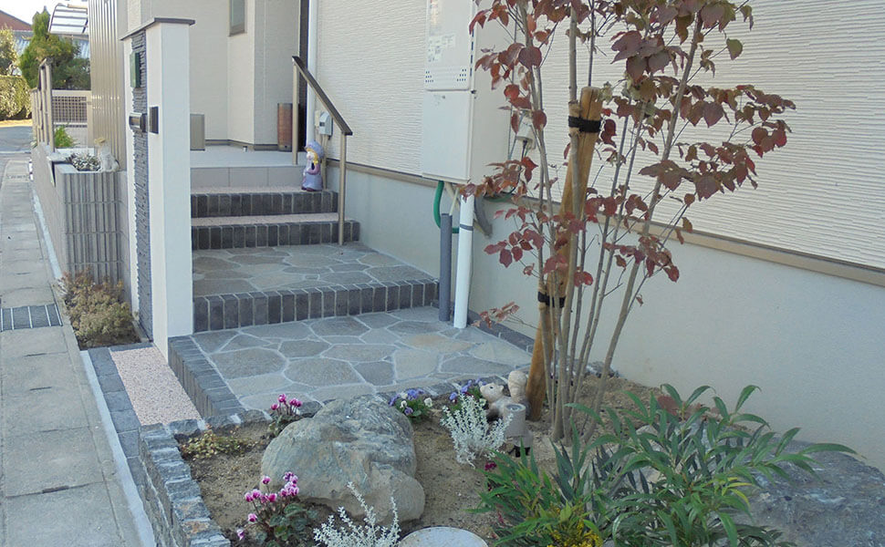 通りに面した門扉の横に植栽スペースがある様子　庭工房